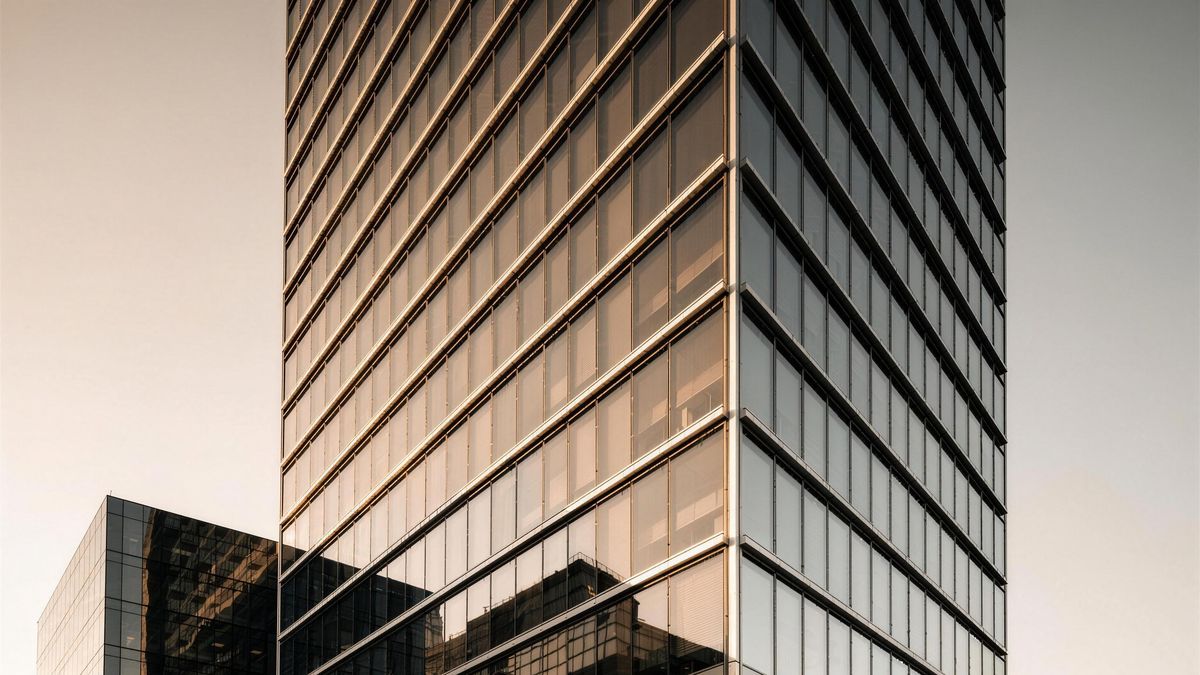 Humber Crossing. A tired 1980s precast office tower reclad in a new unitized curtain wall, floor by floor, fully occupied.